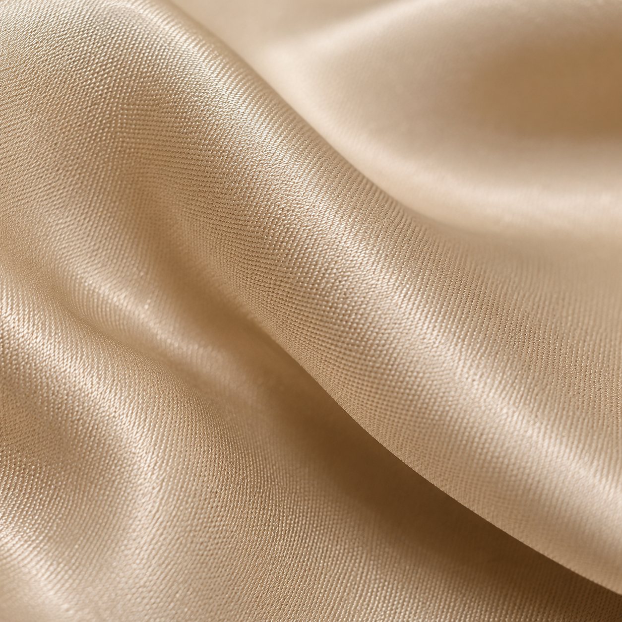 Extreme close-up of the champagne silk weave, its sheen catching the light